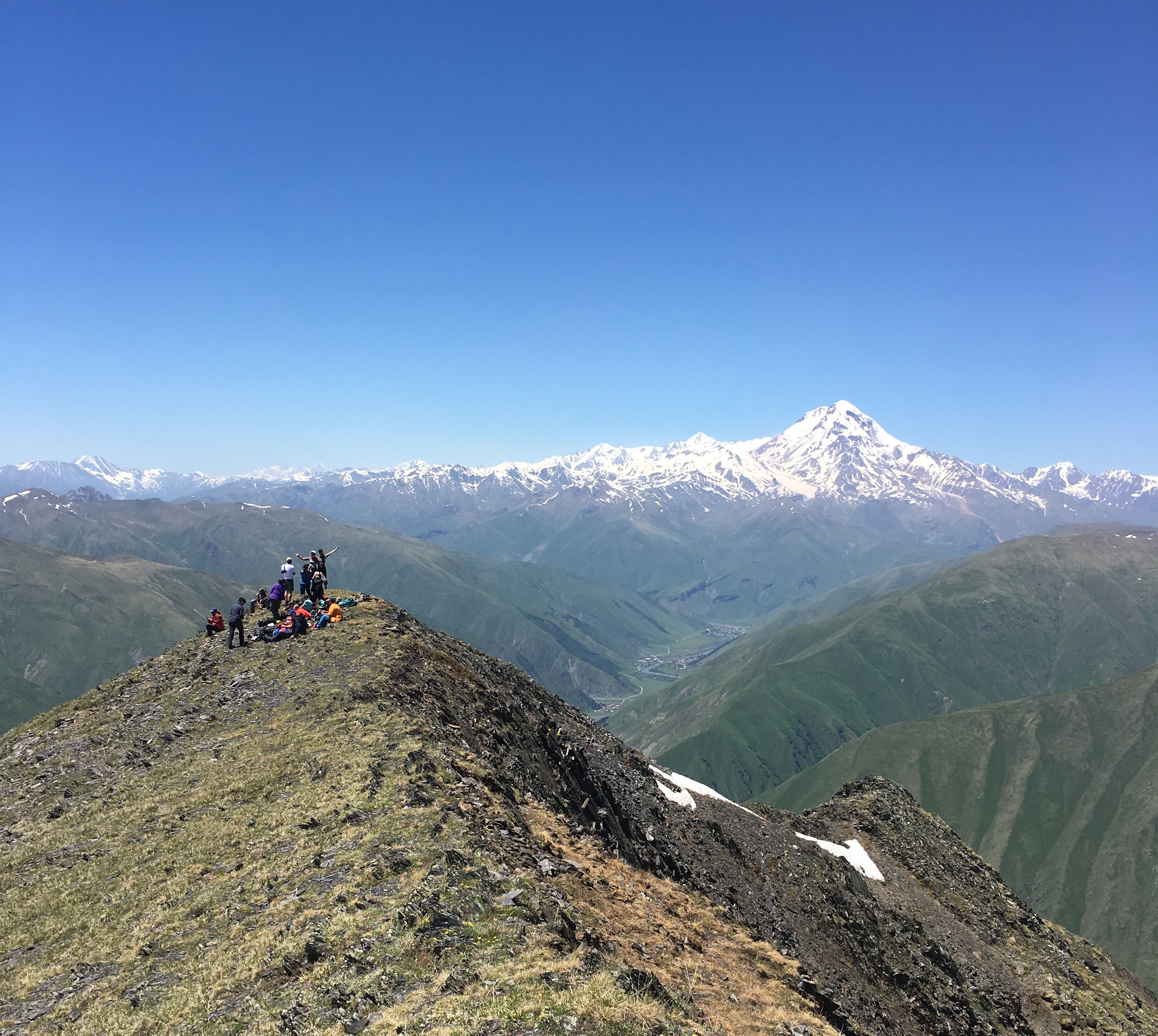 Folk på et fjell med blå himmel