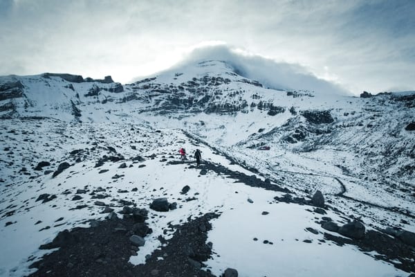 A snowy mountain landscape under a cloudy sky.