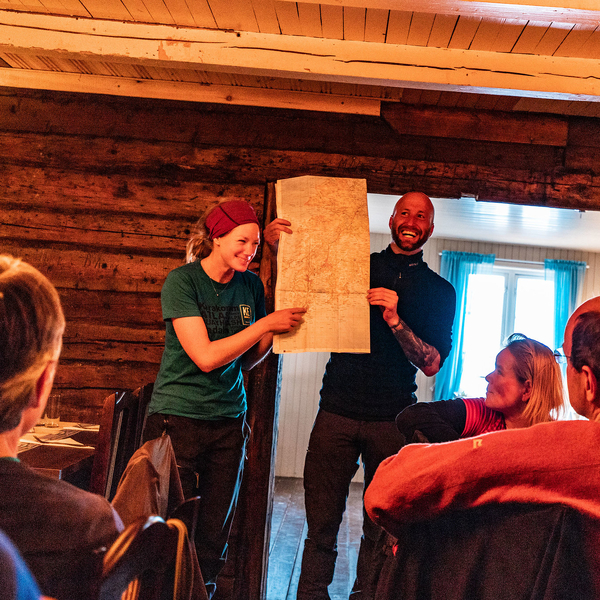 Two persons holding up a map while smiling and laughing.