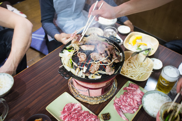 Traditional Japanese food, grilled on a small portable grill on a wooden table and arranged with chopsticks.