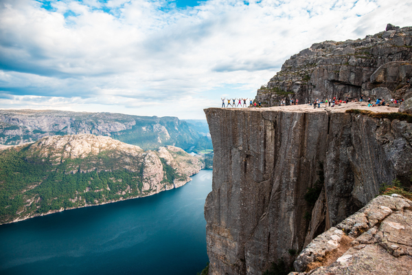 People on Preikestolen overlooking a fjord in Norway.