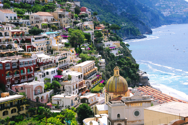 High-angle view of Positano on the Amalfi Coast, Italy, featuring colourful buildings cascading down the cliff to the sea.
