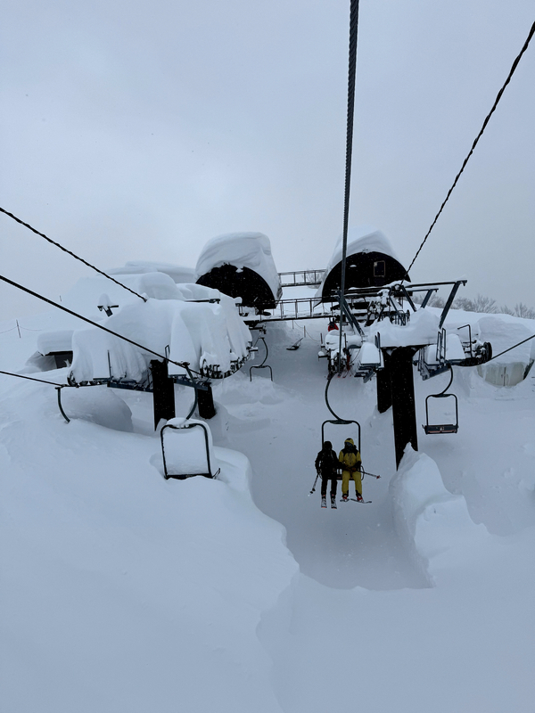 Ski lift with two people and a lot of snow