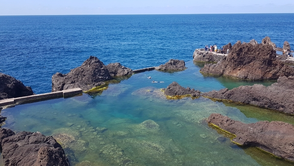 Natural volcanic rock pools by the ocean with clear water