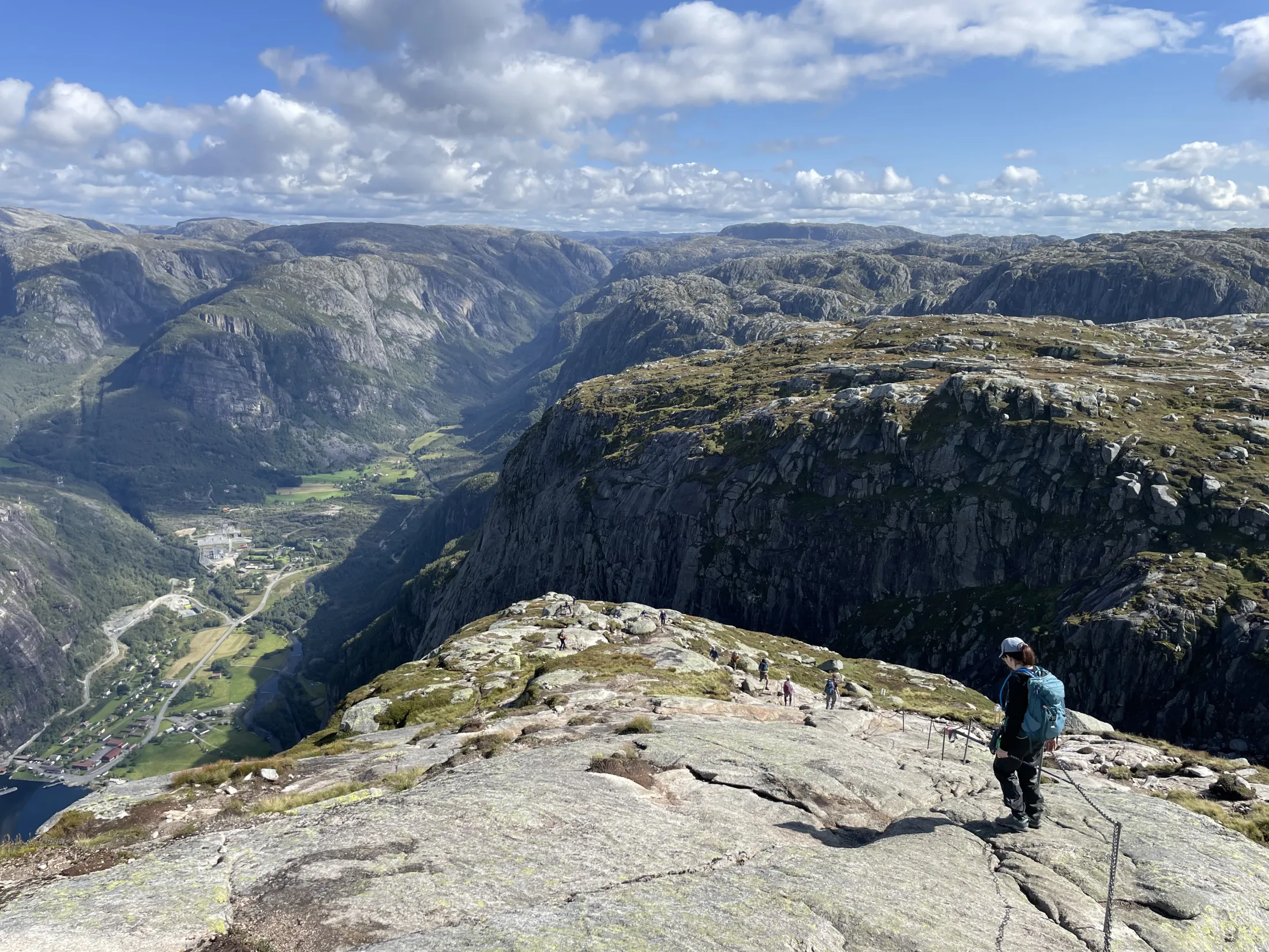 A woman hiking on a mountain with a view down to a valley.