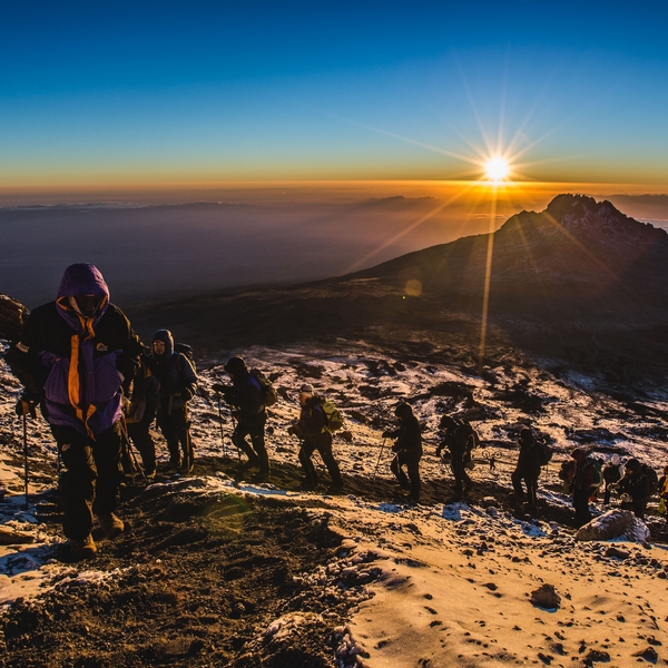 People hiking mountain in sunrise