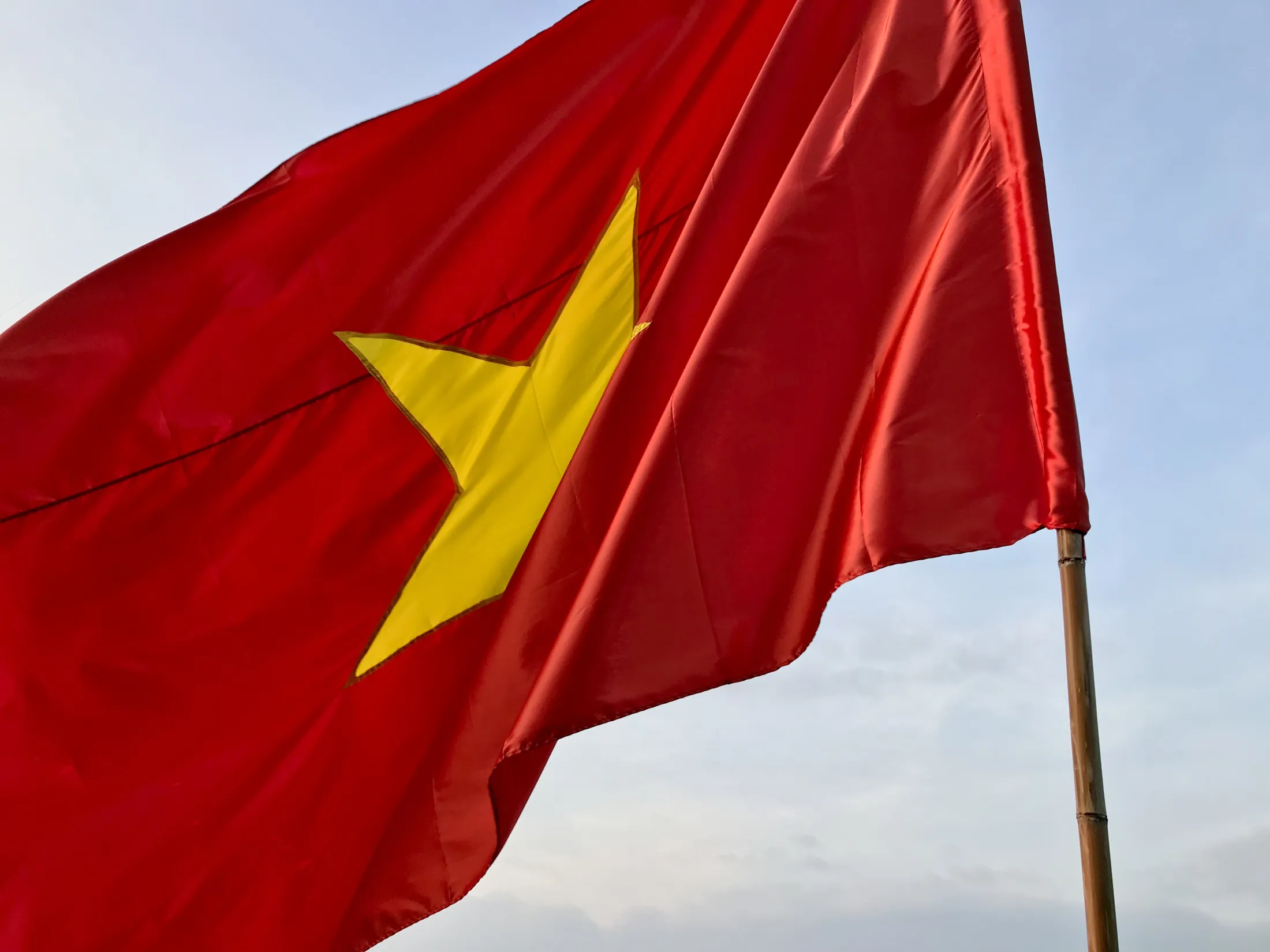 The national flag of Vietnam waving against a blue sky.