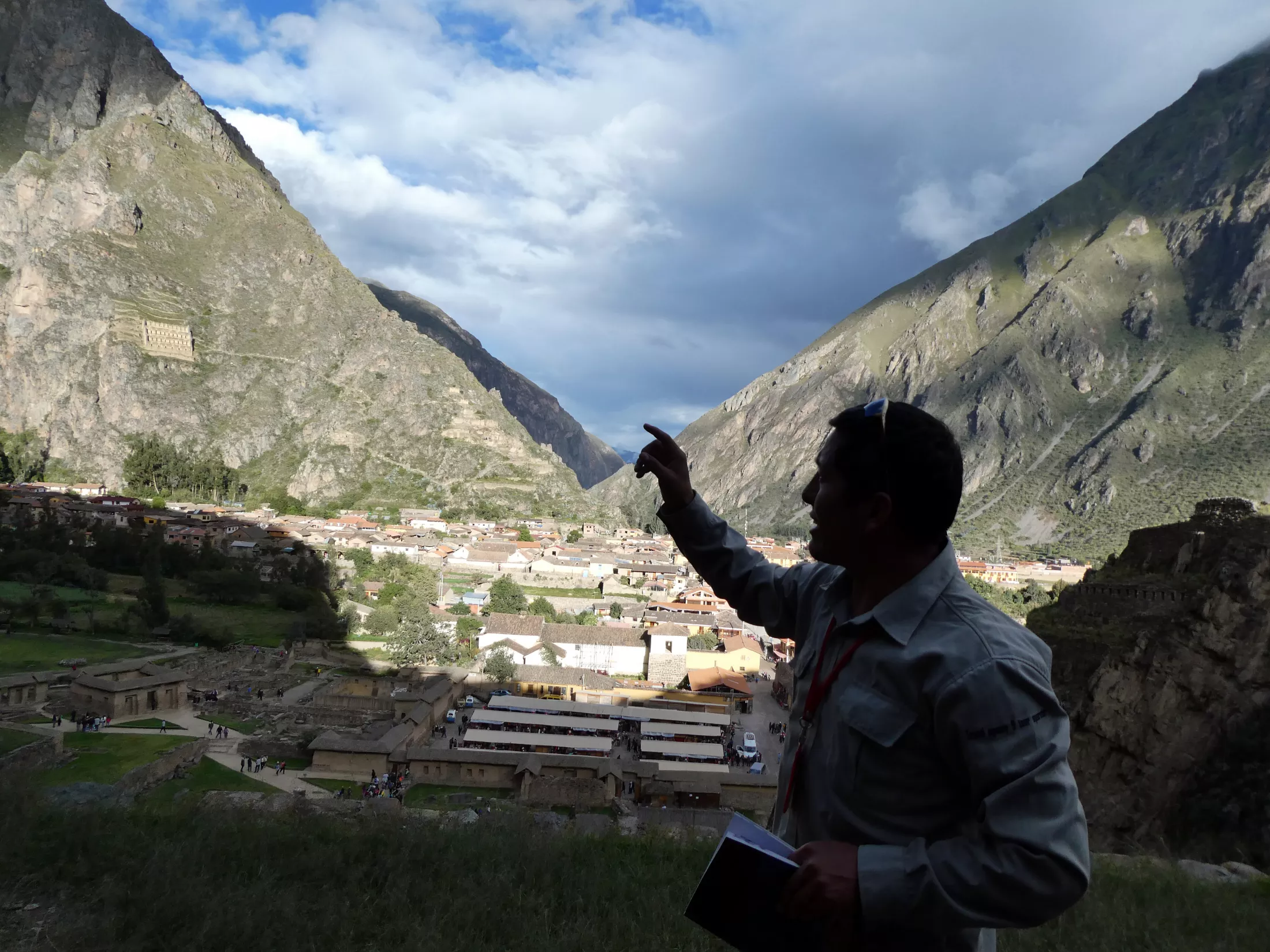 Person pointing to a town in mountains