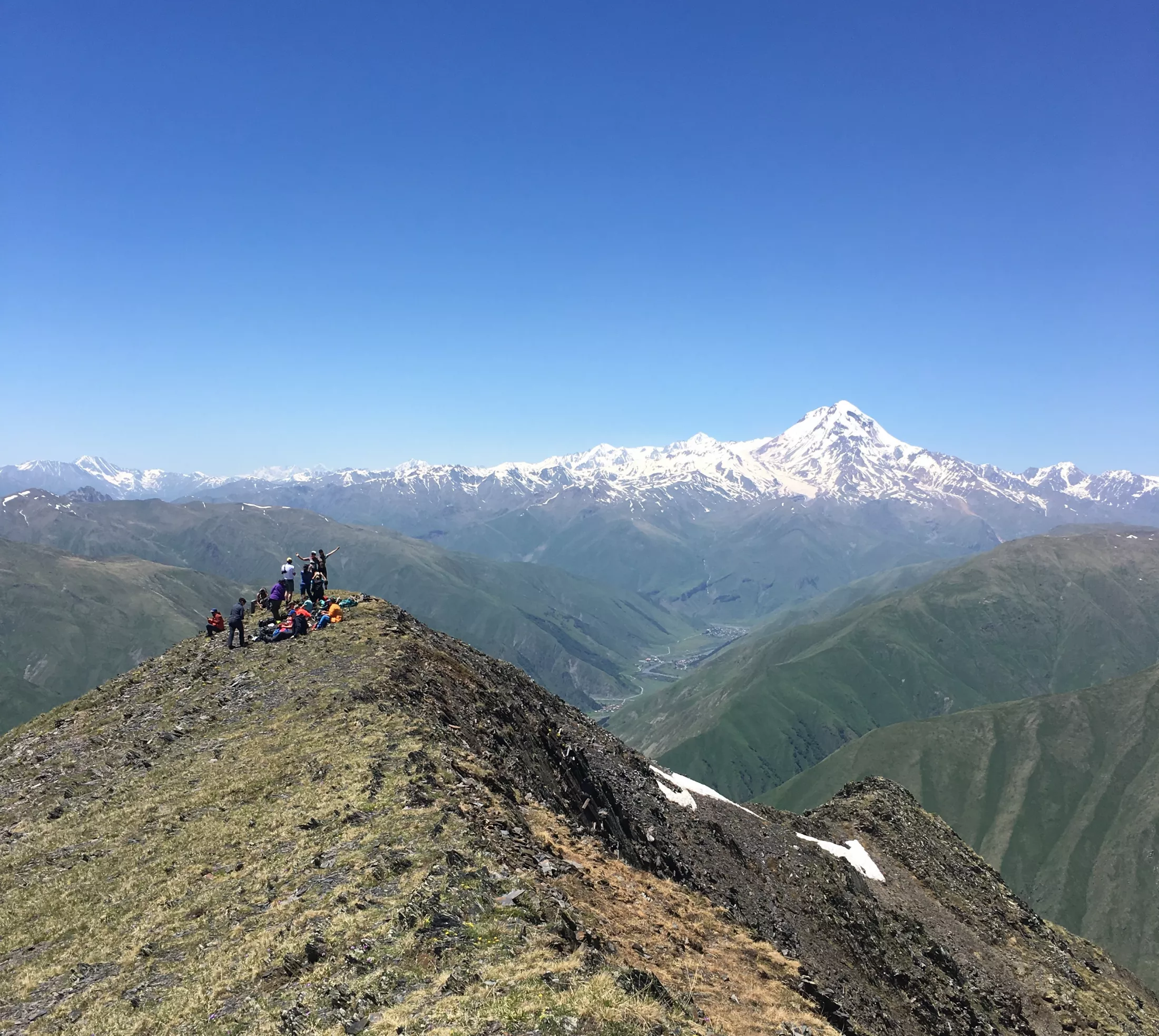 People on a mountain with blue skies