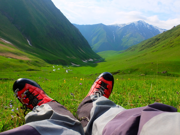 Legs relaxing on a meadow in mountains