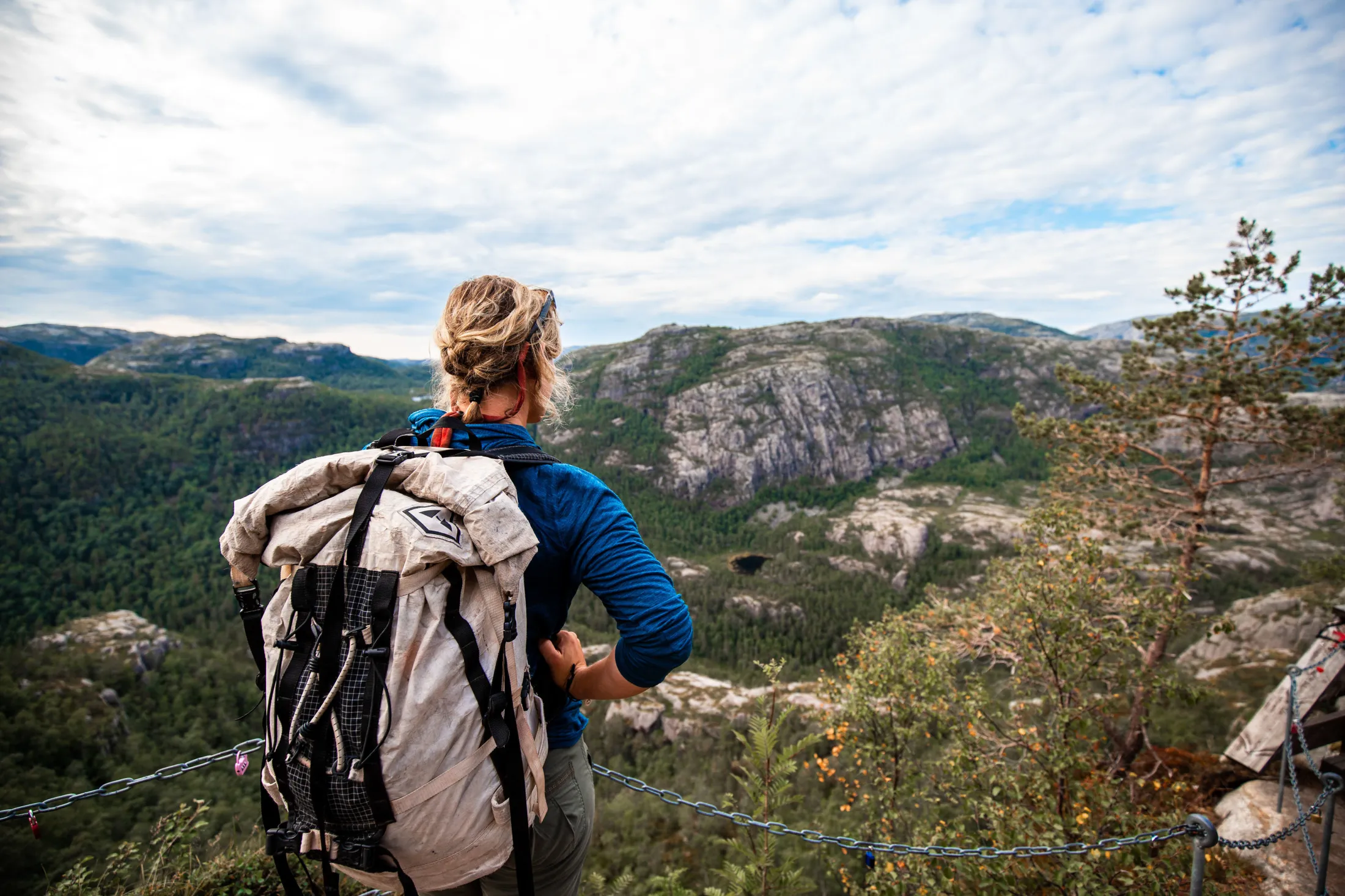 A woman with a backpack looking out over the mountains.