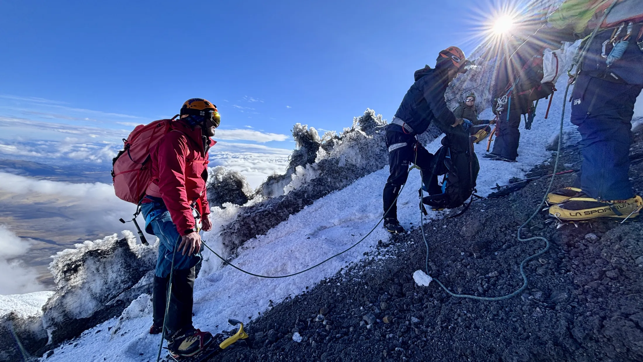 Mountain team roped up on slope of mountain 