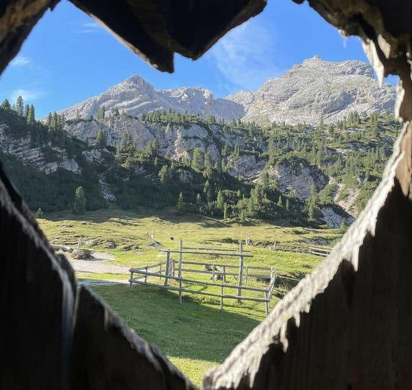 A heart-carved window looking at mountains