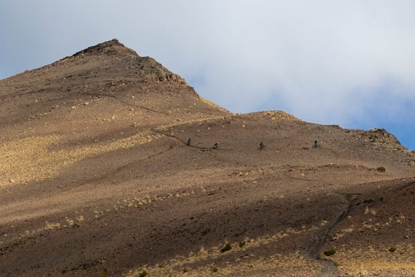 A rocky, barren mountain peak under a cloudy sky.