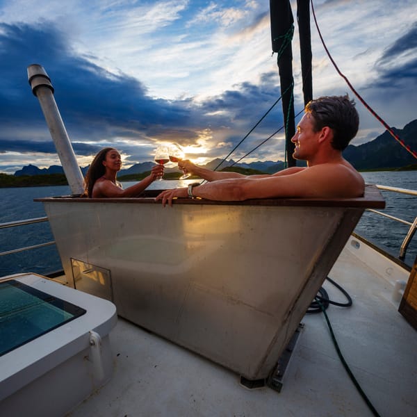 Two people in a hot tub on a boat in the ocean