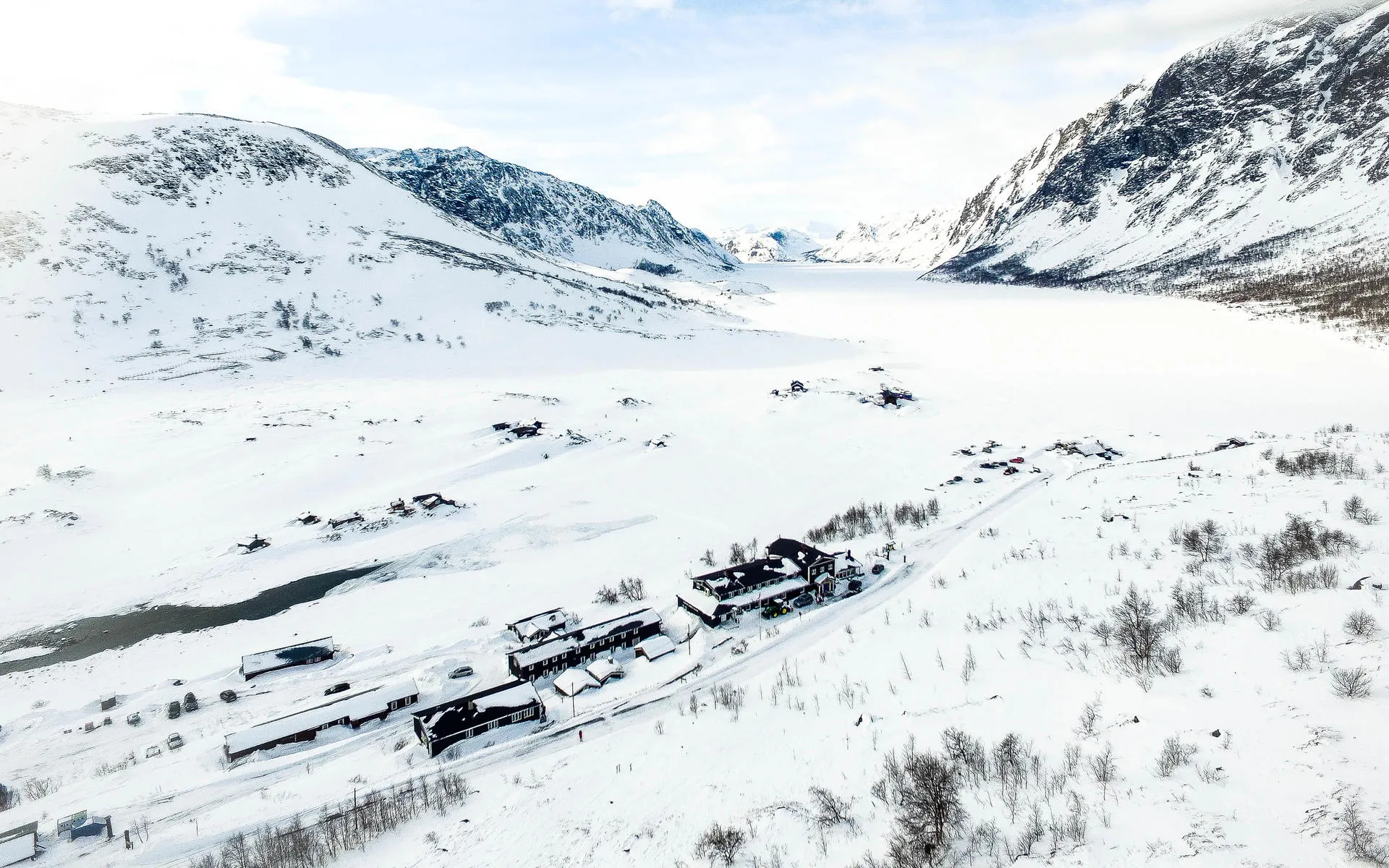 Mountain Lodge in winter landscape with mountains in the back.