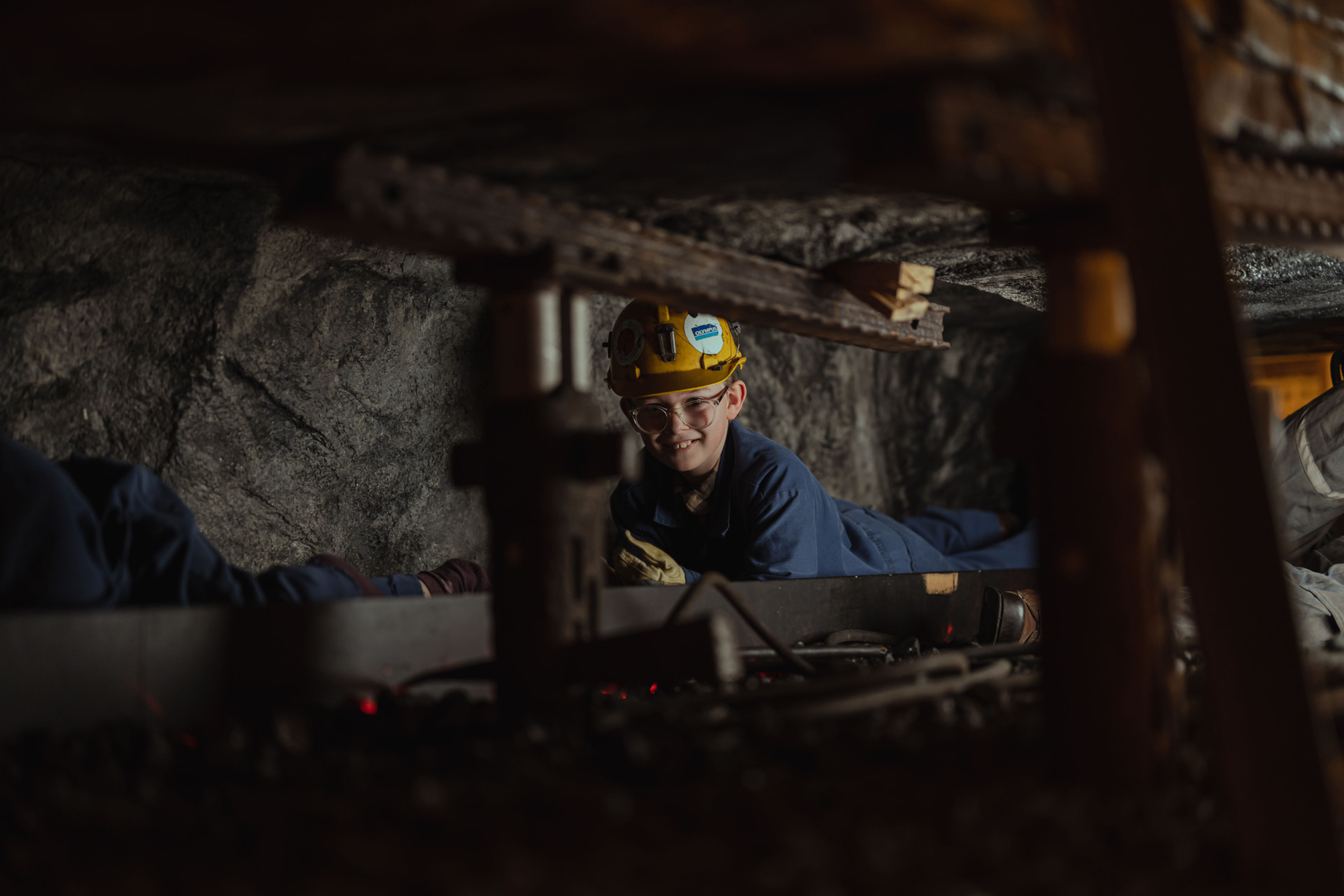 A child crawling through an old mine shaft smiling