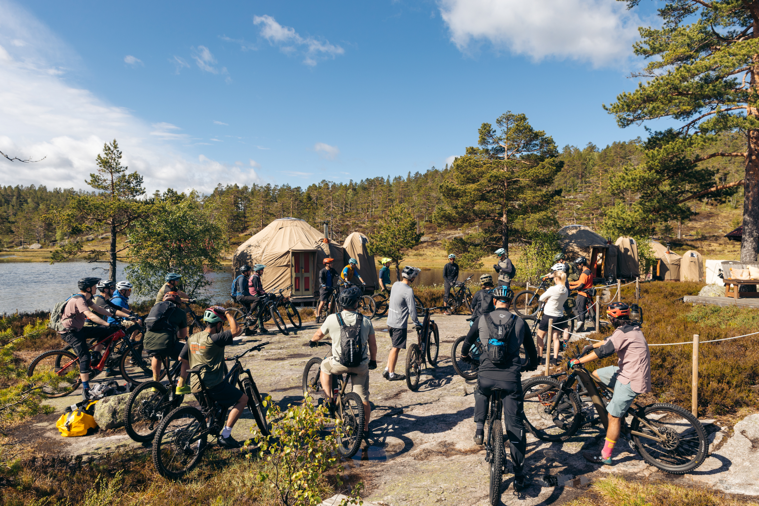 Group of mountain bikers in a forest and a yurt