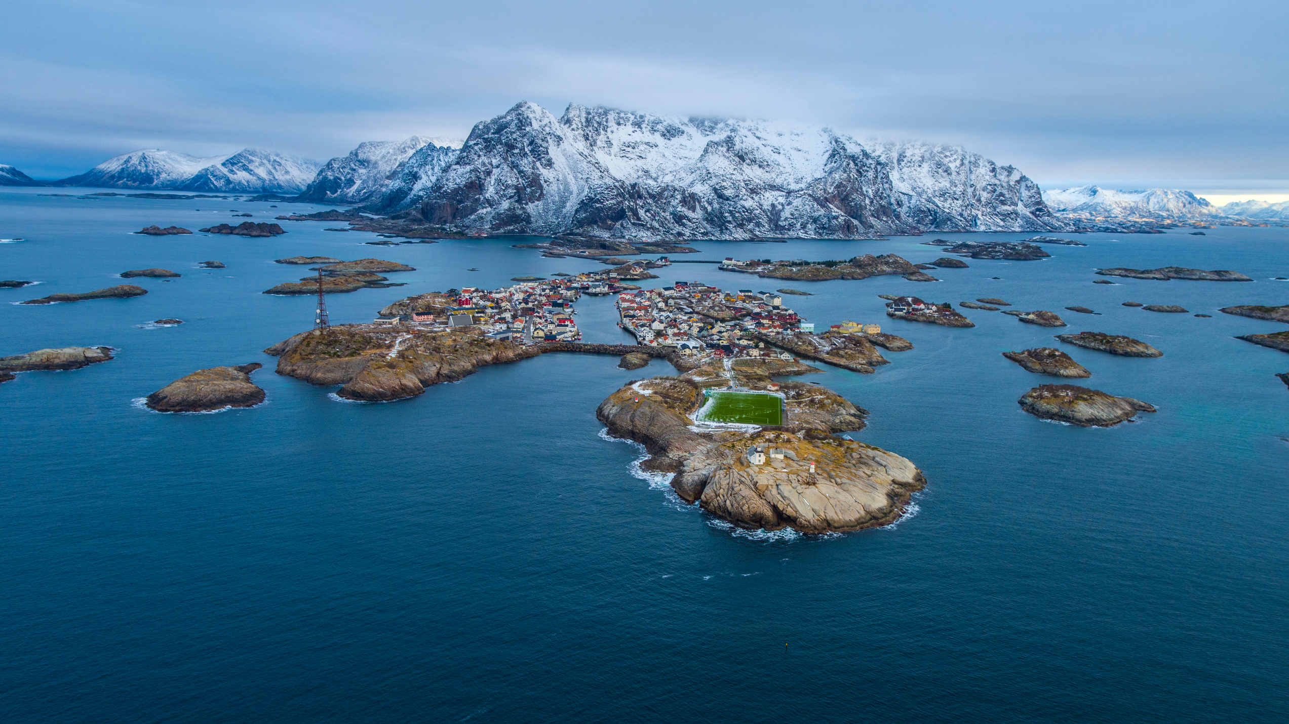 Islands in front of snow covered mountains and a football field