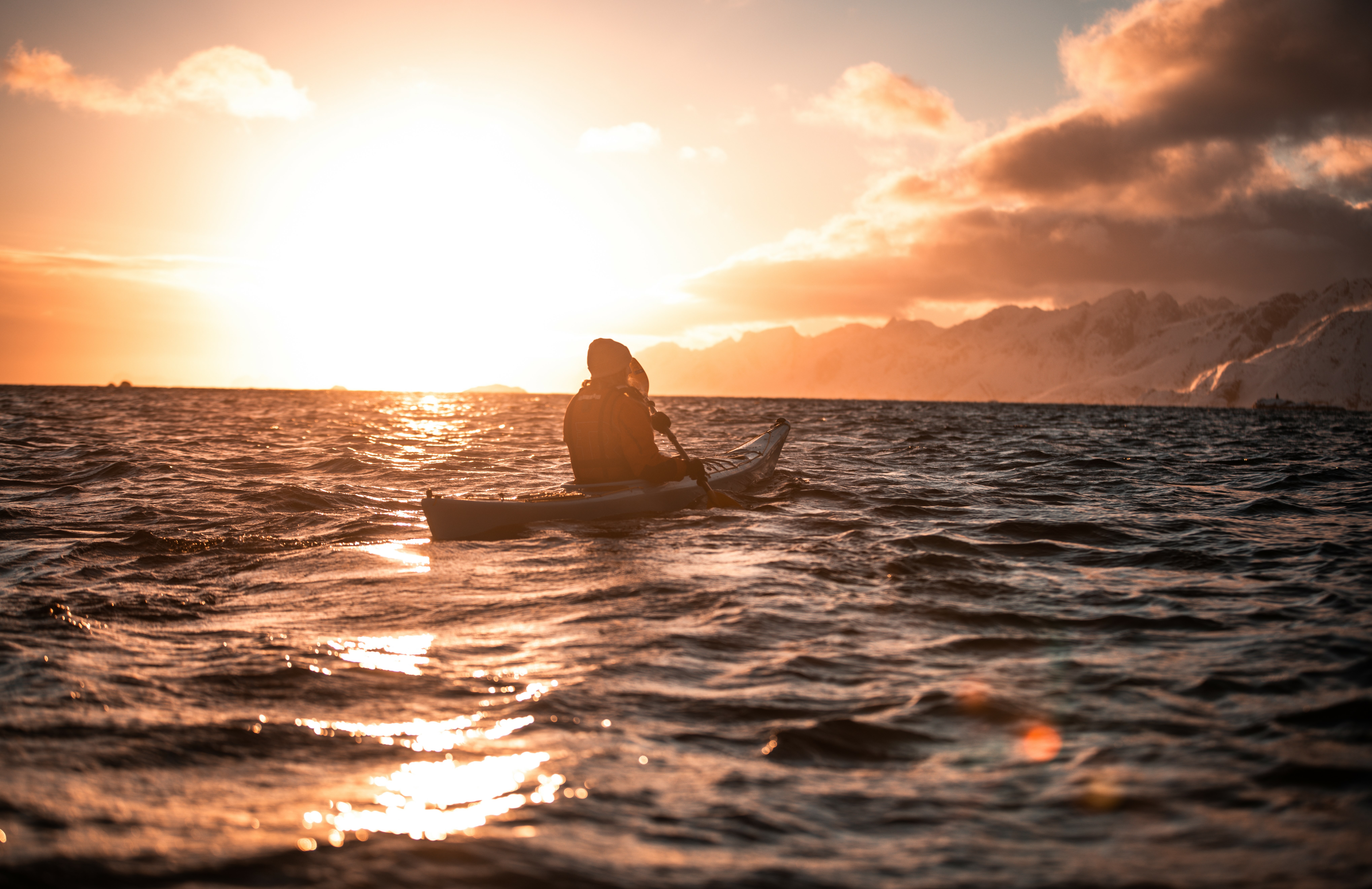 A person kayaking in the sunset