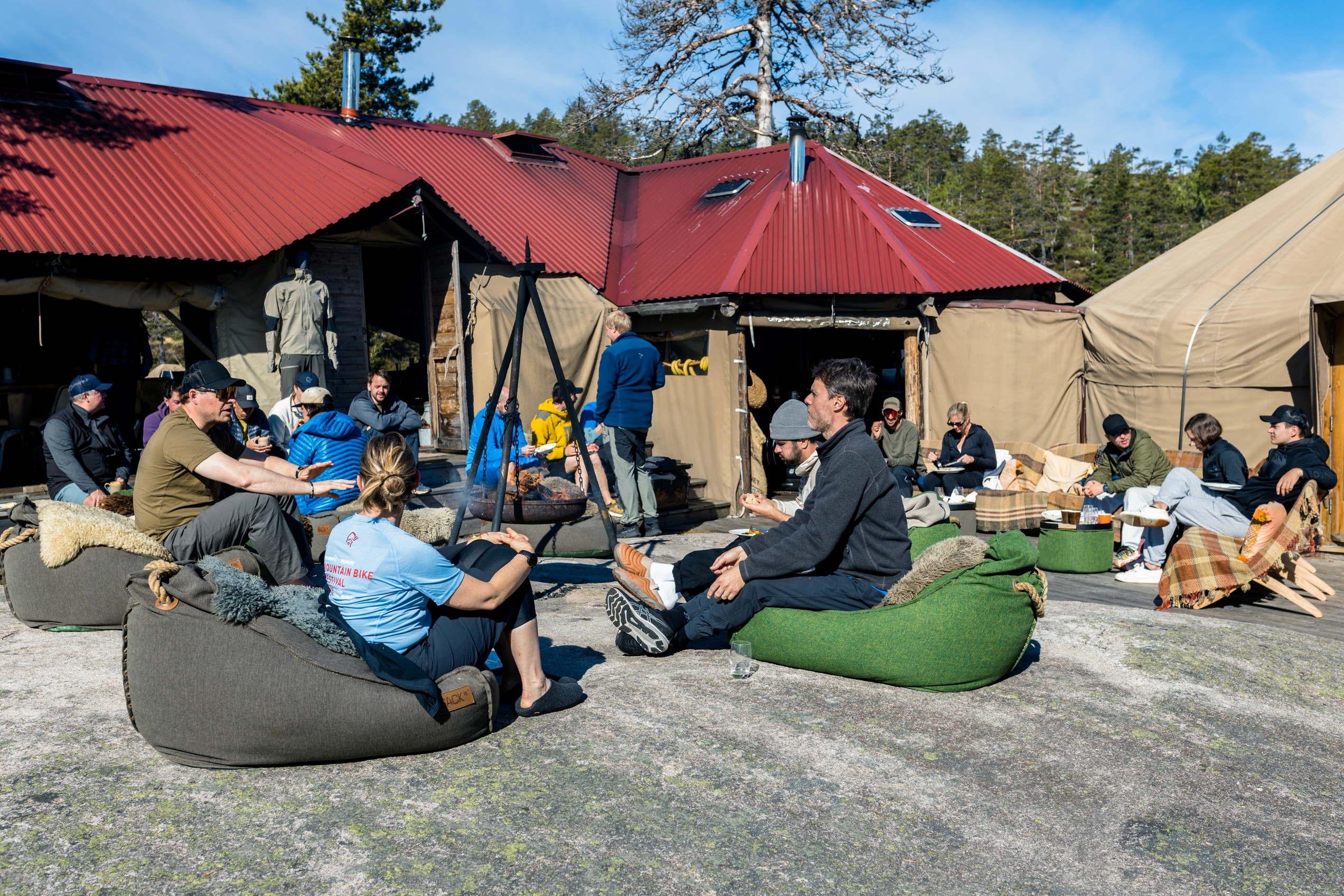 Group of people on bean bag chairs in the forest in a camp
