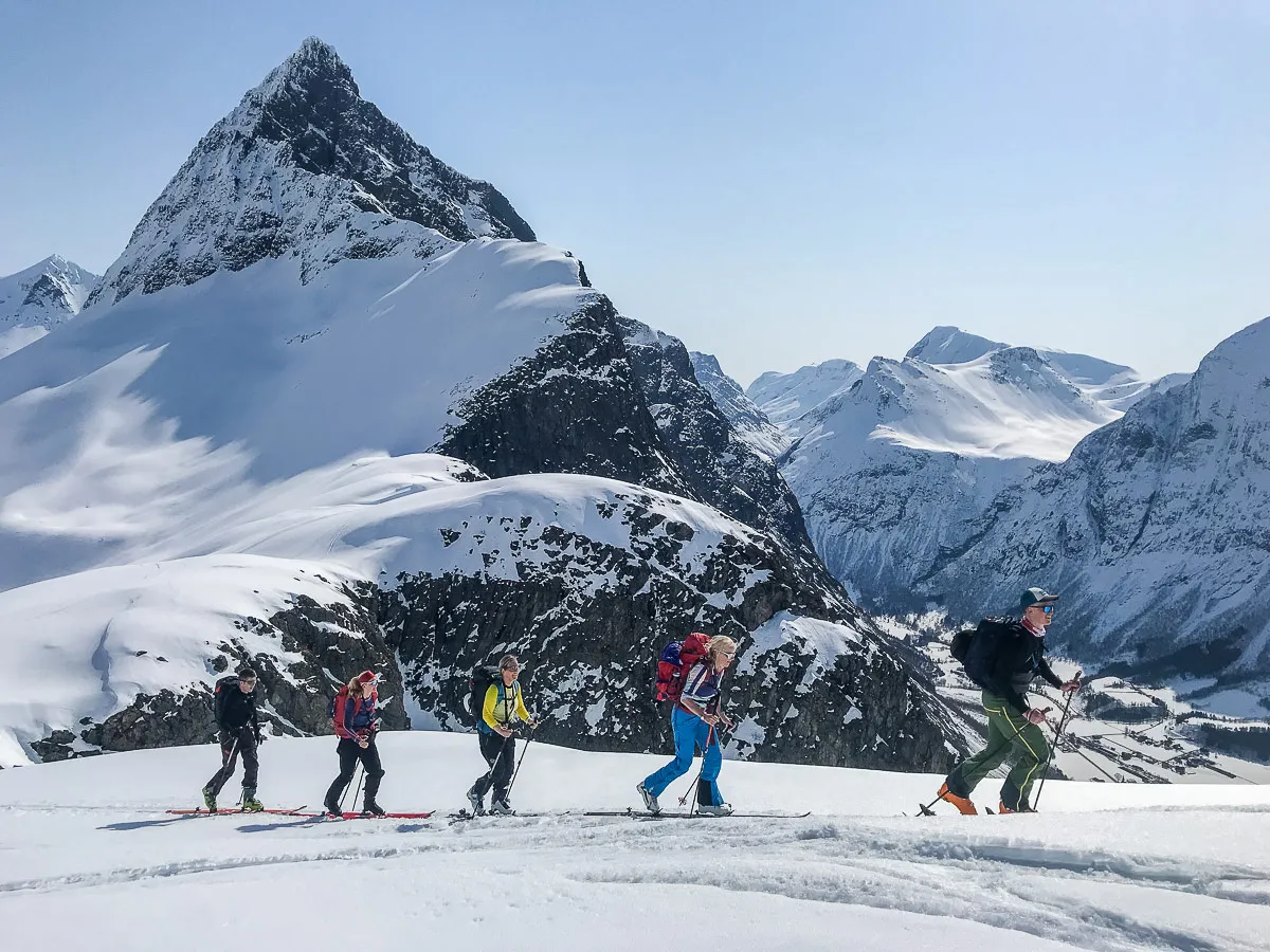 Five skiers in front of the mountain Slogen