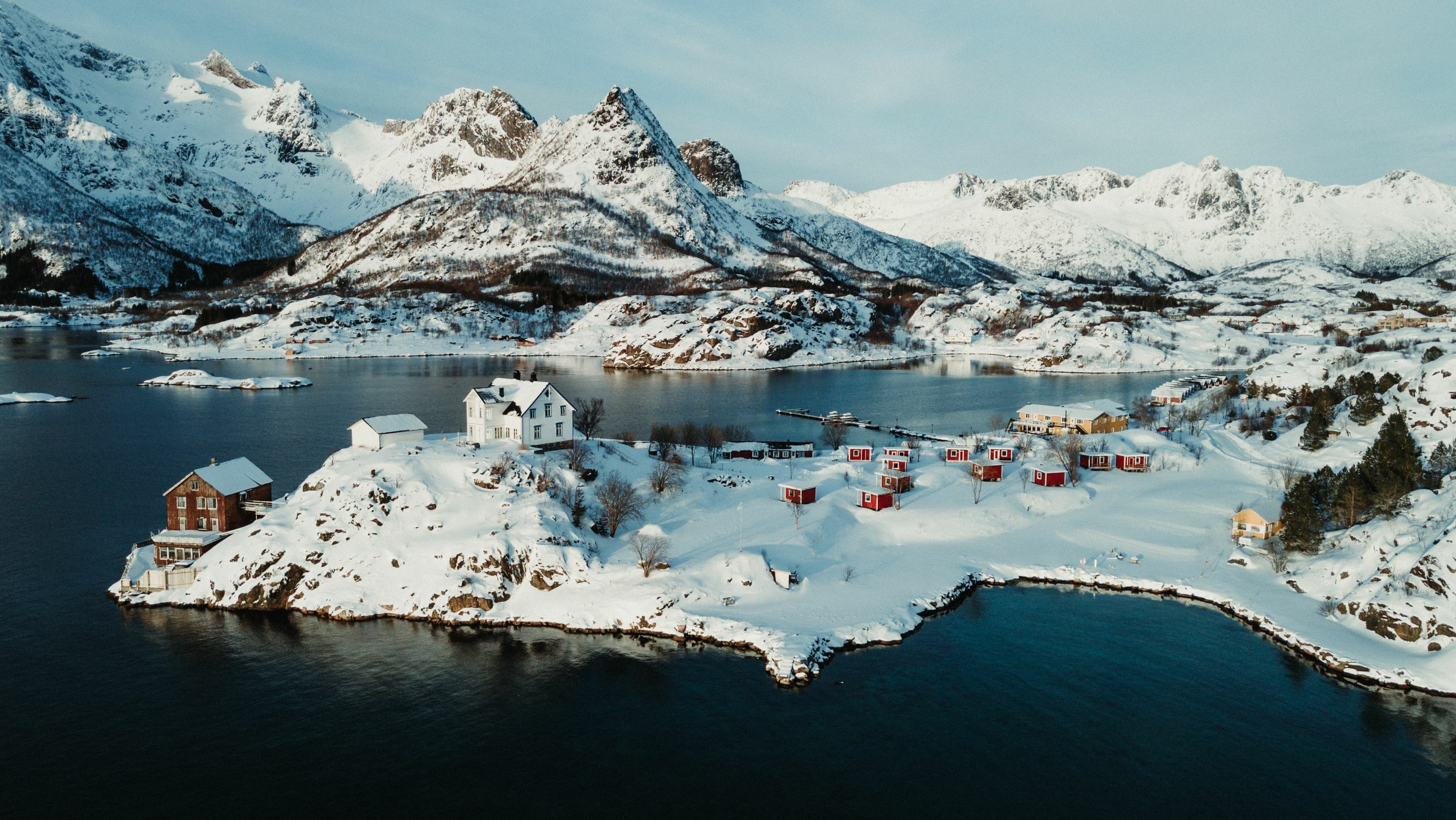 Scattered houses on an snowy island with mountains