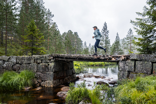A runner on a small bridge in the forest