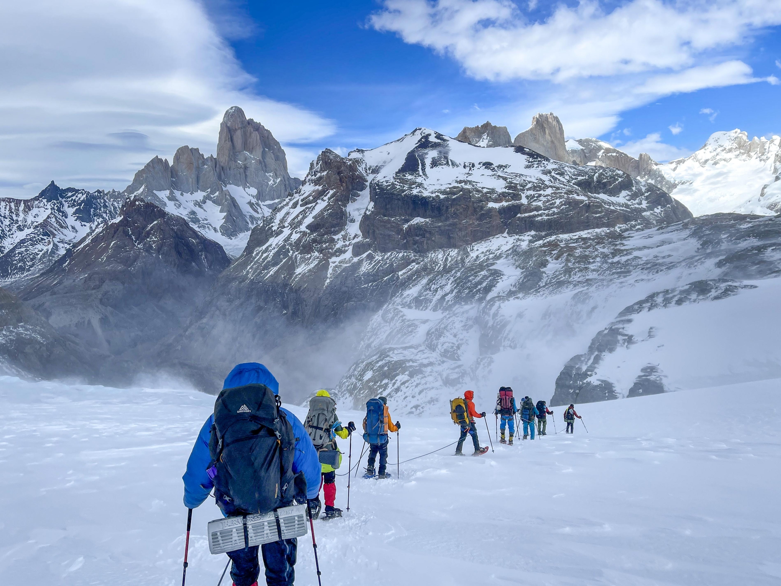 A group of people walking on a glacier in the mountains