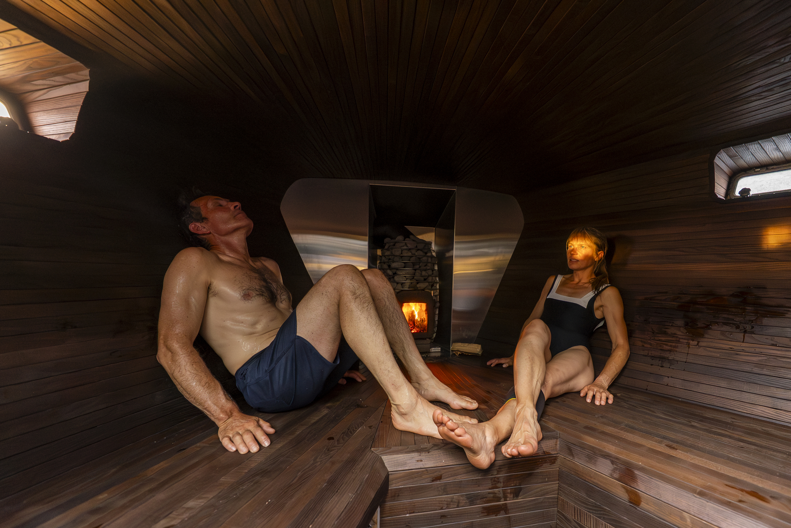 Two people sitting in a sauna in the aft of a sail boat