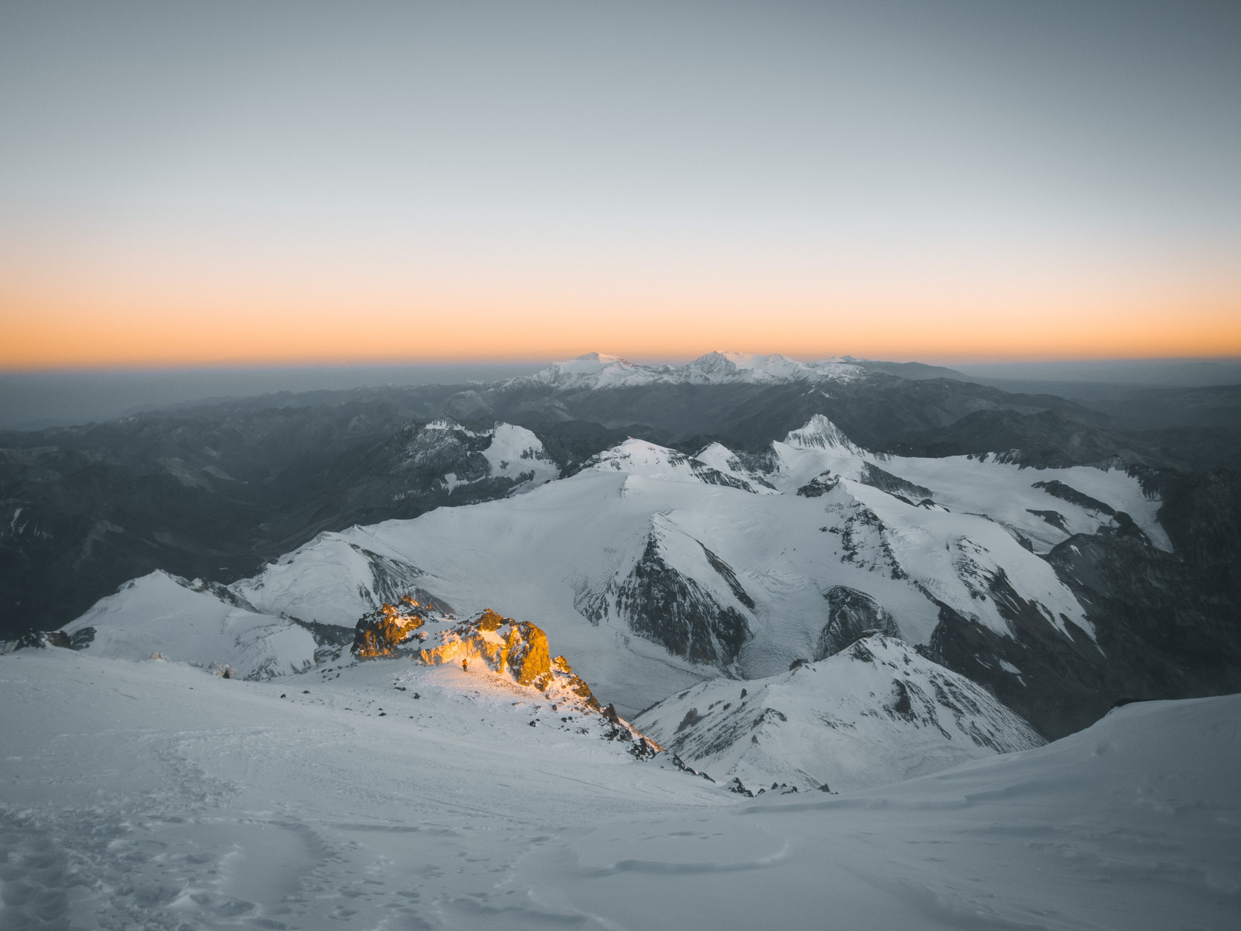 Sunrise from the summit of a snow covered mountain