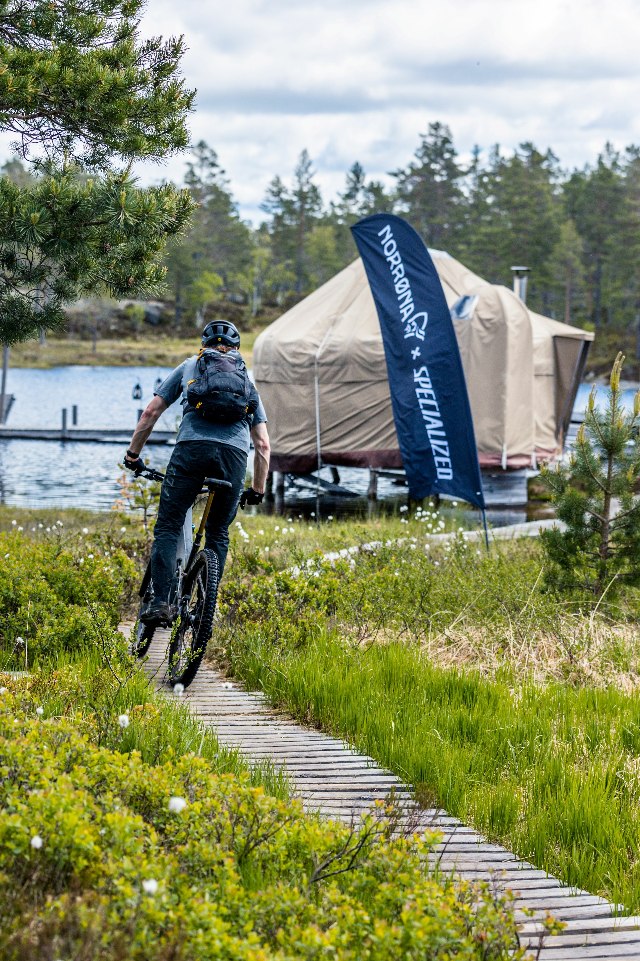 Biker on a path with yurts behind