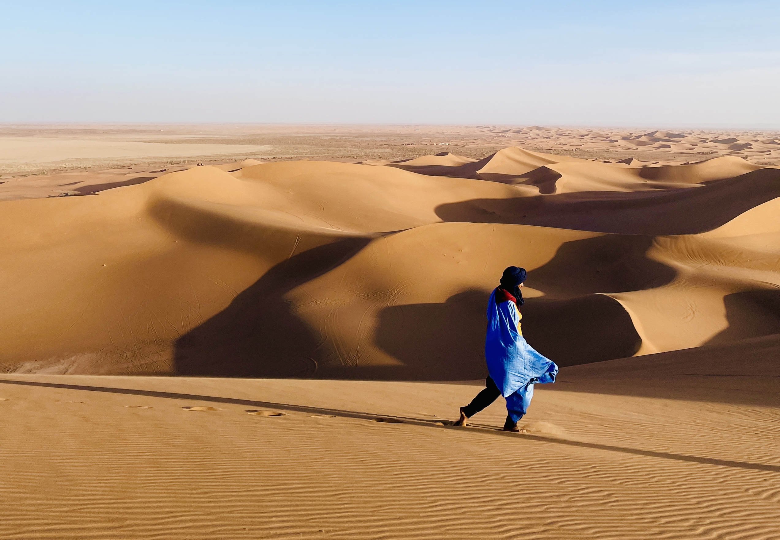 Person walking through sand dunes