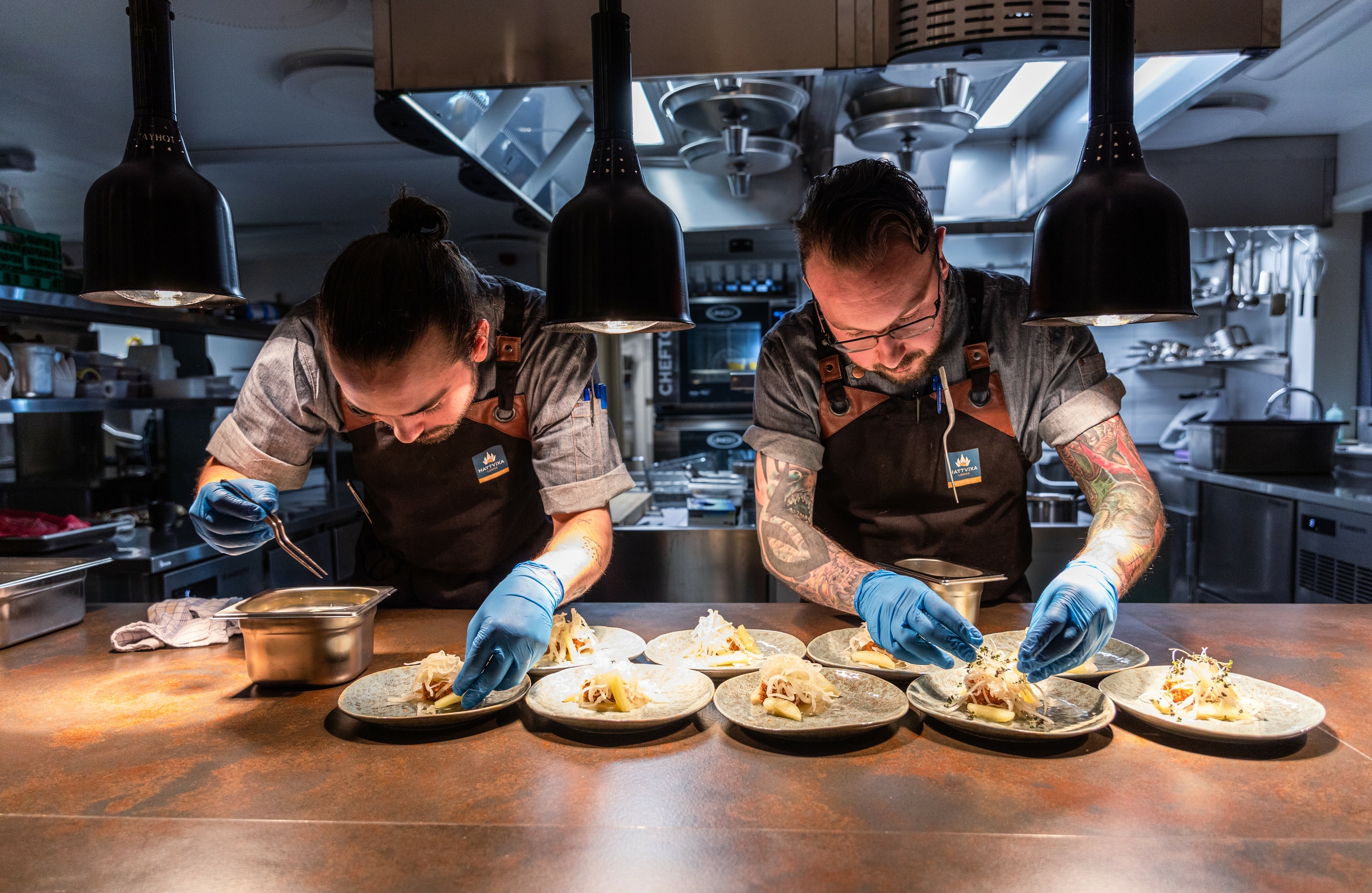 Two chefs preparing food in a kitchen