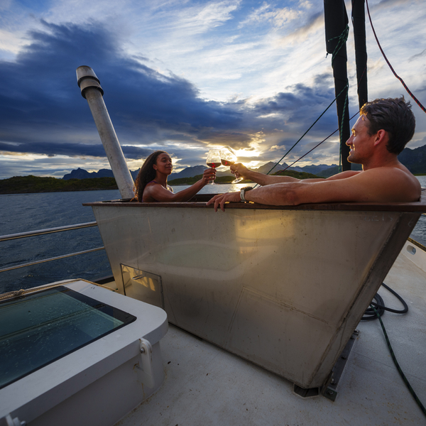 Two people in a hot tub on a boat in the ocean