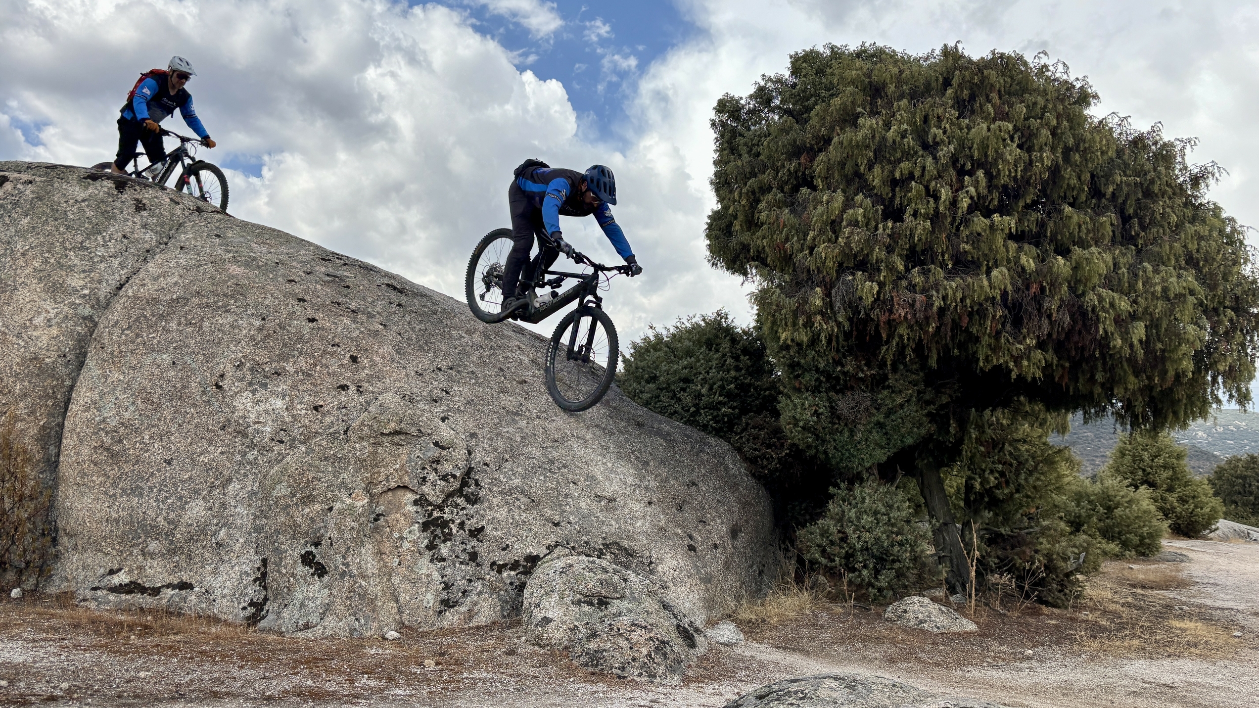 Mountain biker rolling off rock