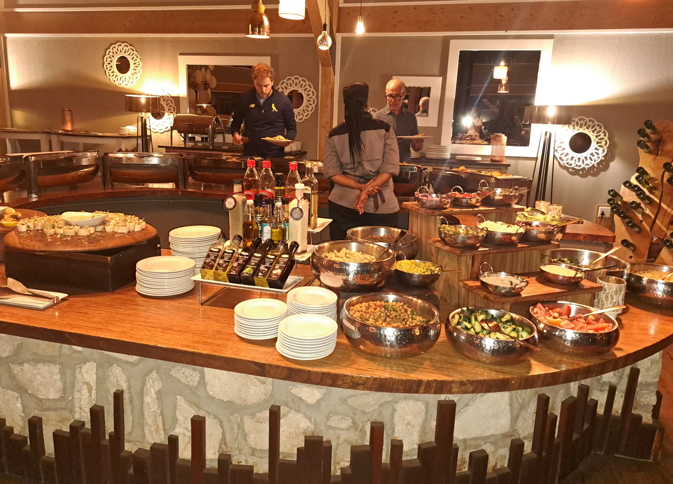 Hotellbuffet med en servitør, og to gjester som forskyner seg.
