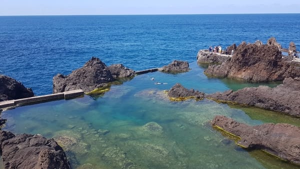 Naturlige vulkanske steinbassenger ved havet med klart vann