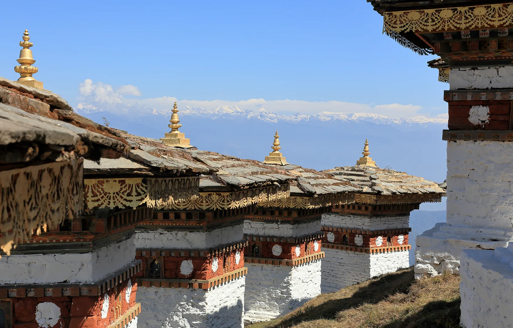 Gammel arkitektur i Bhutan med fjell i bakgrunnen.