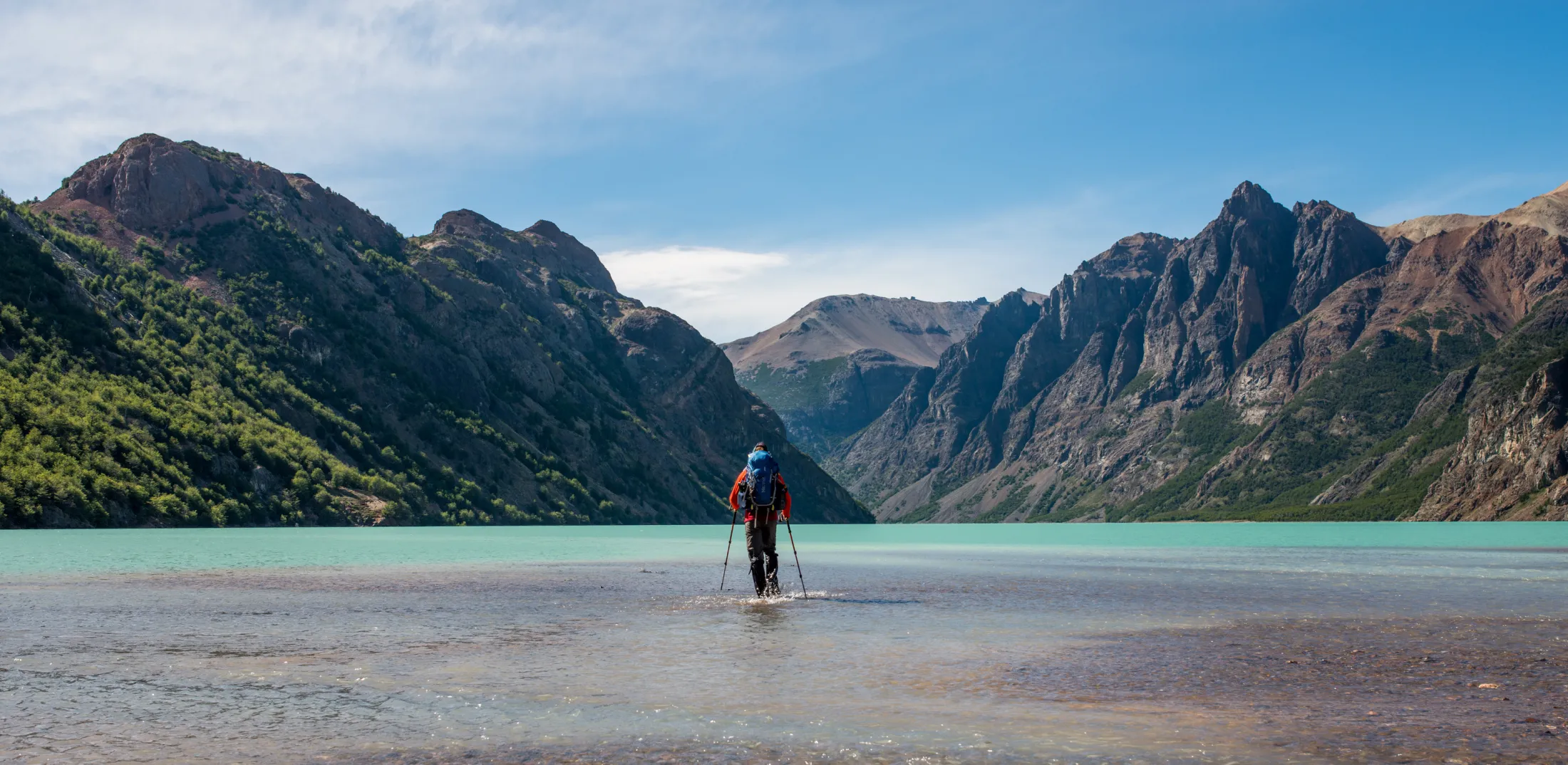 Person som går i vannet i fjellene.