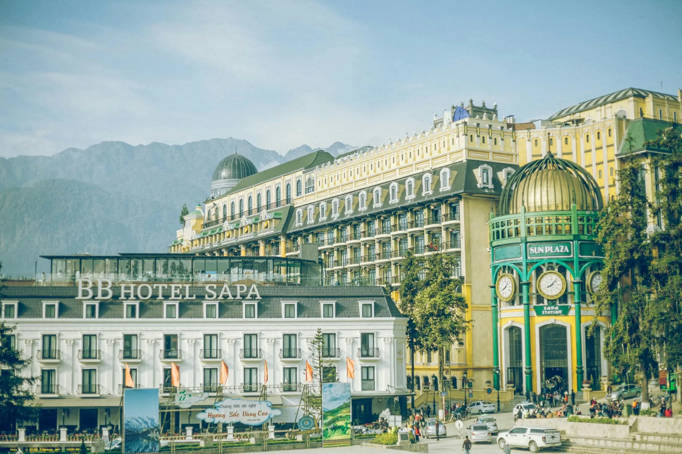 Et vidt bilde av et stort hotell i Sapa i Vietnam, med europeisk-inspirert arkitektur mot en bakgrunn av fjell.