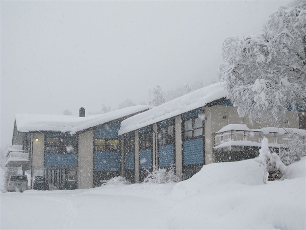 En moderne bygning i et snølandskap under en snøstorm.