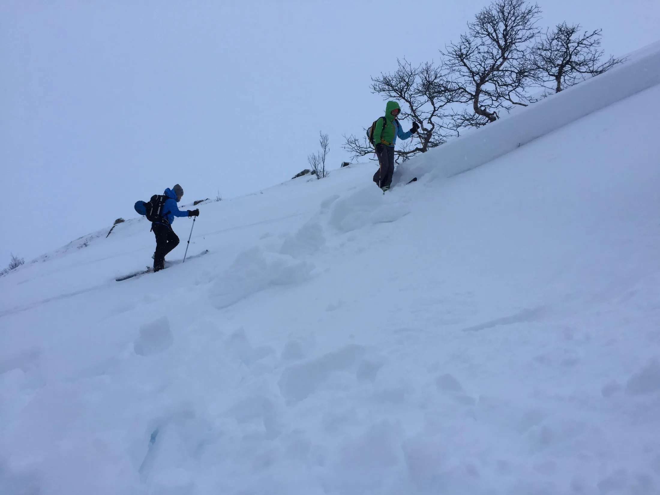 To skiløpere på tur i en snøbakke med utløst skred.