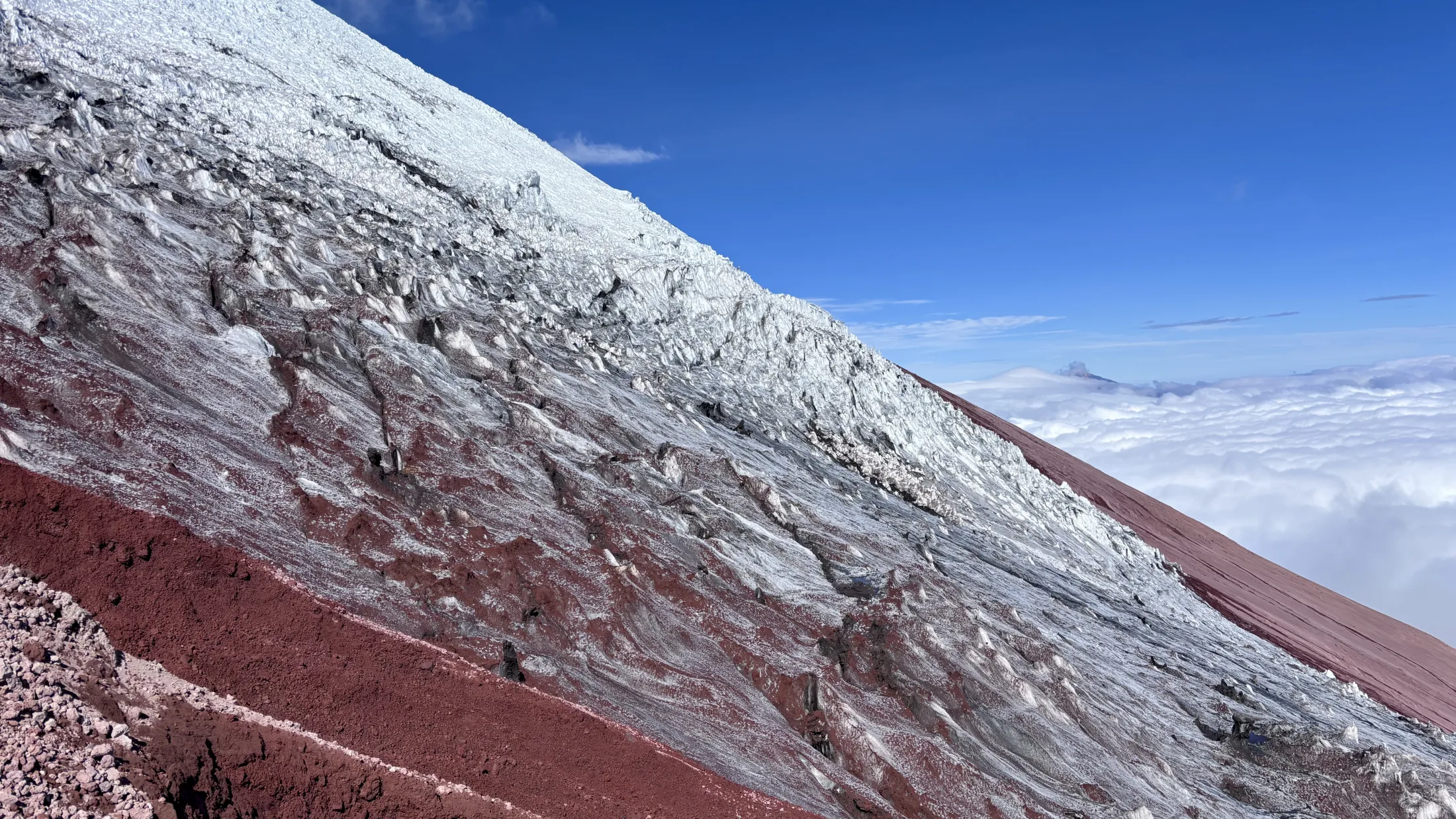 Snø og rødt fjell i fjellsiden