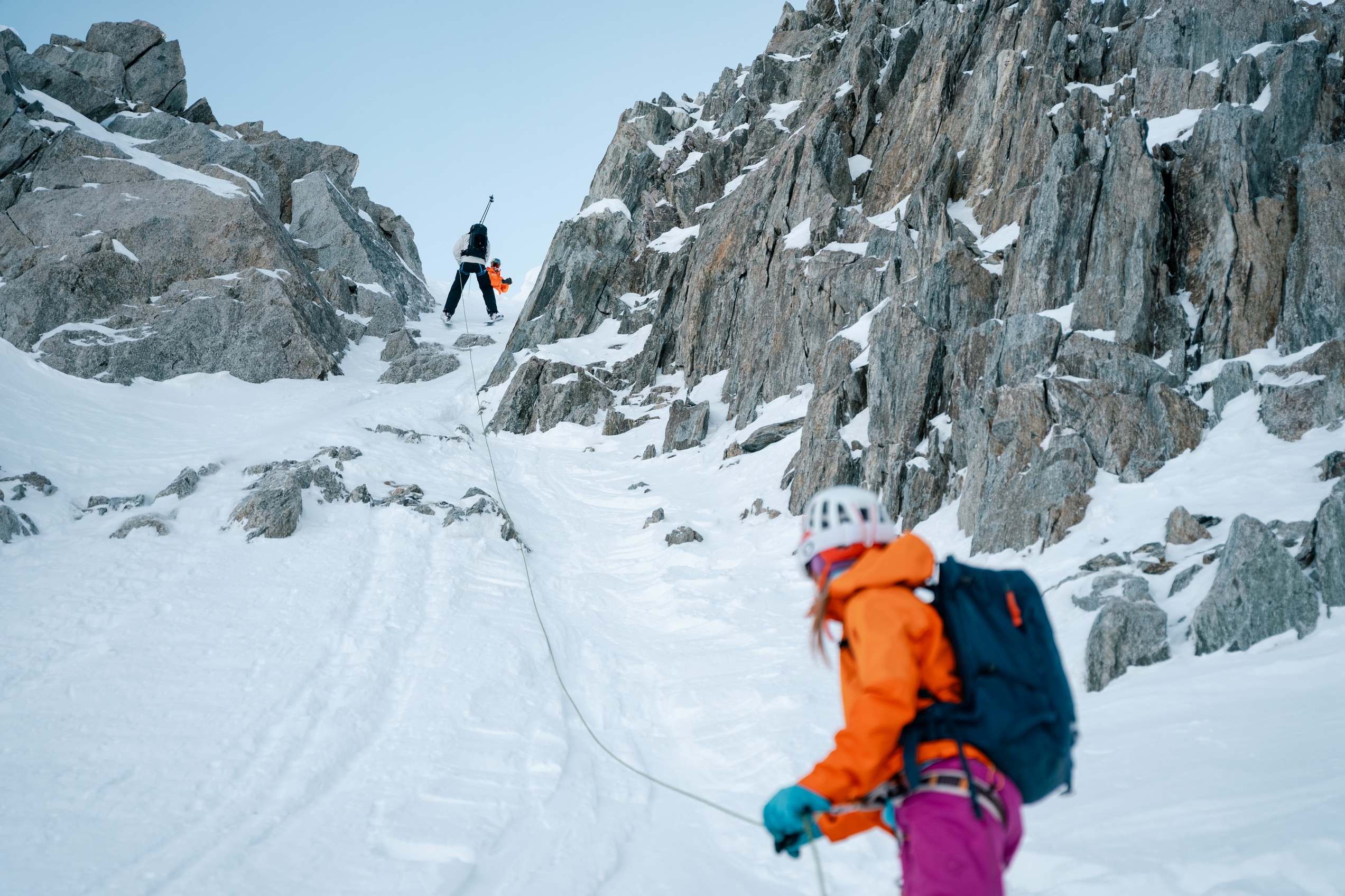 To skikjørere som rappellerer ned en renne